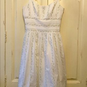 White dress with floral embroidery.